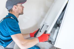 Repairman opening the front panel to a furnace to begin inspection and repair.